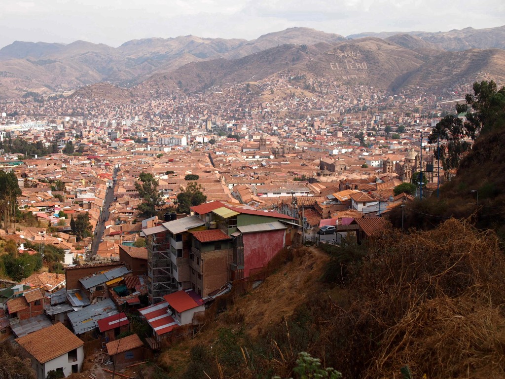 View over the red roofs of Cusco with Andean mountains visible in the background