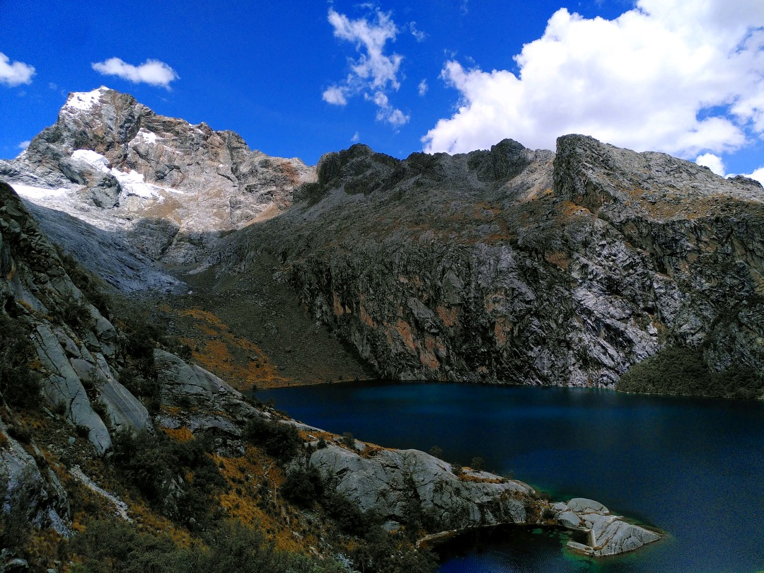 The same blue lagoon from an elevated point of view and a massive grey rock wall in the background