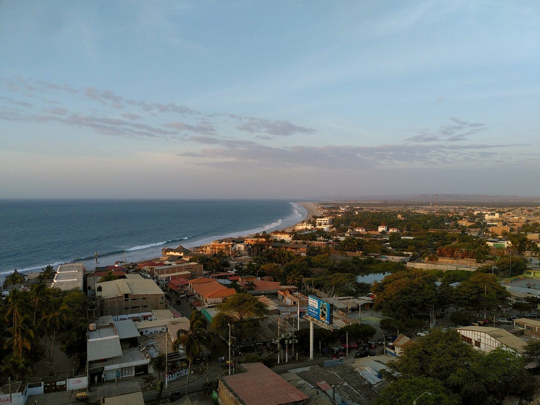 View of a little beach town during sunset from a nearby hill