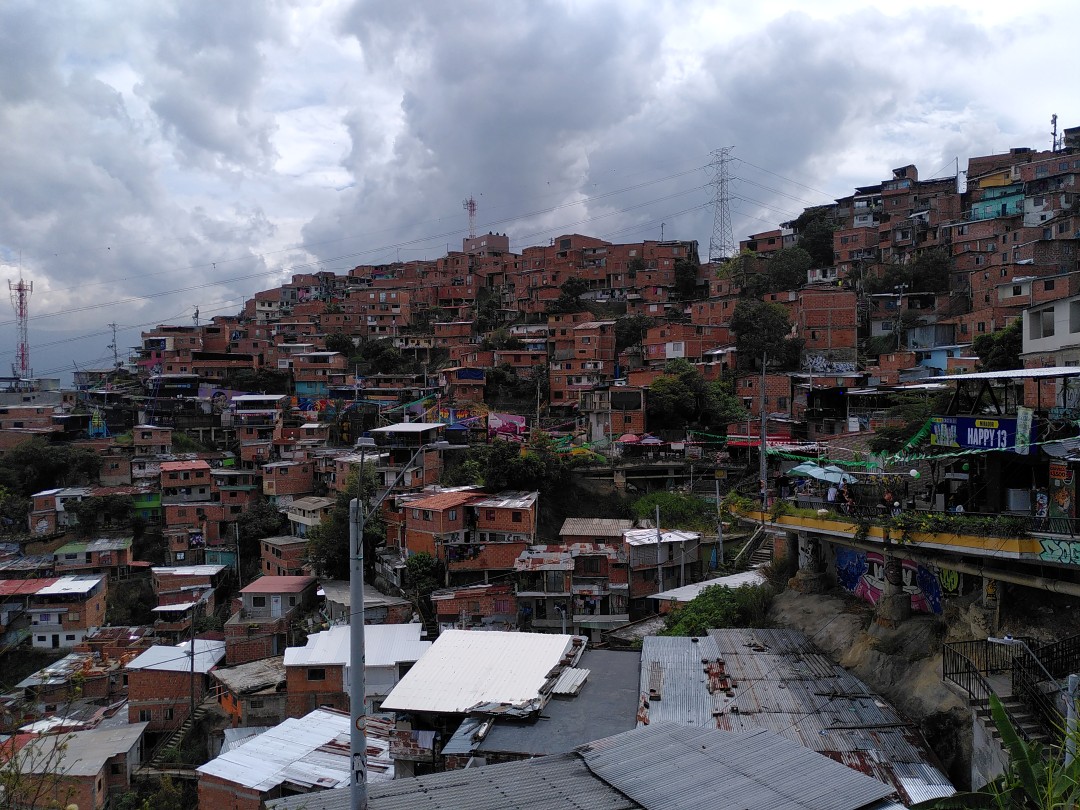 Makeshift houses from red bricks built densely on the slope of a hill